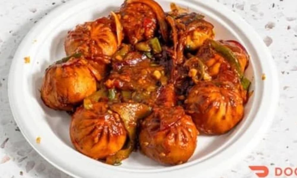 Veg chili momos in a spicy red sauce